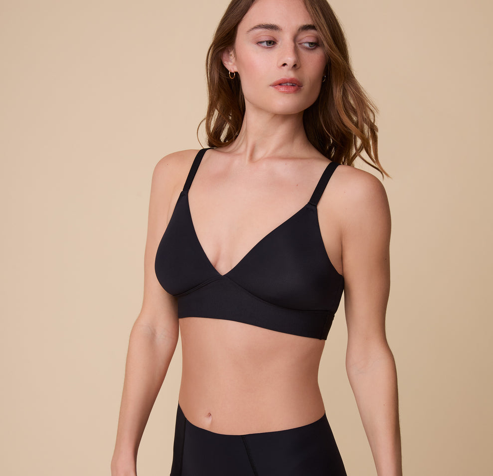 A close-up of Gracie wearing the Bliss Triangle Bralette in Black, highlighting the deep V-neckline and minimal, everyday style. sizing: Gracie wears size Small