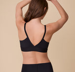 A back view of Gracie in the Bliss Triangle Bralette in Black, showcasing the sleek, low-cut design, adjustable straps, and comfortable band.
