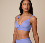 Three quarter angle of Nemesis wearing the Bliss Triangle Bralette in Dusk. Her pose showcases the soft contouring designed for natural shaping and support.