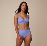 Full-body shot of Nemesis wearing the Bliss Triangle Bralette and matching Bliss Highwaist Brief in Dusk. She stands with a relaxed pose, emphasizing the flattering, smooth fit of both pieces.