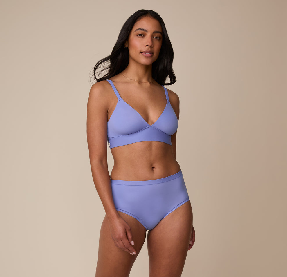 Full-body shot of Nemesis wearing the Bliss Triangle Bralette and matching Bliss Highwaist Brief in Dusk. She stands with a relaxed pose, emphasizing the flattering, smooth fit of both pieces.