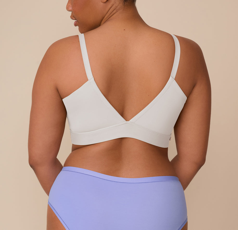 Back view of Zarria wearing the Bliss Triangle Bralette in Frost. The image shows the bralette’s deep V-back and front adjustable straps, emphasizing comfort and a sleek silhouette.