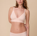A close-up of Gracie wearing the Bliss Triangle Bralette in Rose. The deep V-neckline and soft, seamless fabric highlight the bralette’s minimal, everyday comfort. sizing: Gracie wears size Small