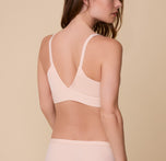 A back view of Gracie wearing the Bliss Triangle Bralette in Rose, showcasing the low V-back and adjustable straps for a customizable fit.