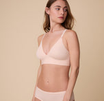 Gracie poses in the Bliss Triangle Bralette in Rose, highlighting its wireless, unpadded design and lightweight support.