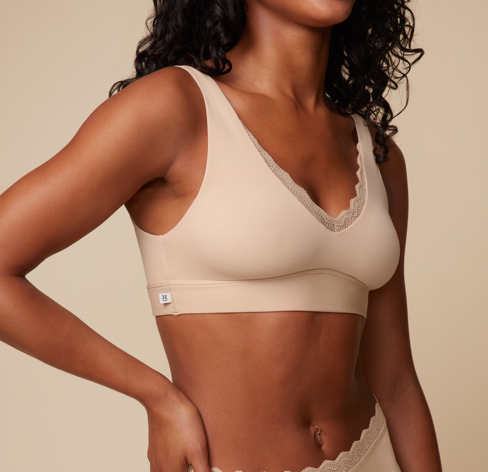 Close-up side view of Ally wearing the Bliss Lace Bralette in Beige. The image focuses on the bralette’s soft fabric and lace detail. sizing: Ally wears size Small