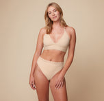 Megan posing in the Bliss Lace Halterneck Bralette and matching Highwaist Lace Thong in Beige. The front-facing image showcases the bralette’s delicate lace detail and supportive halterneck design.