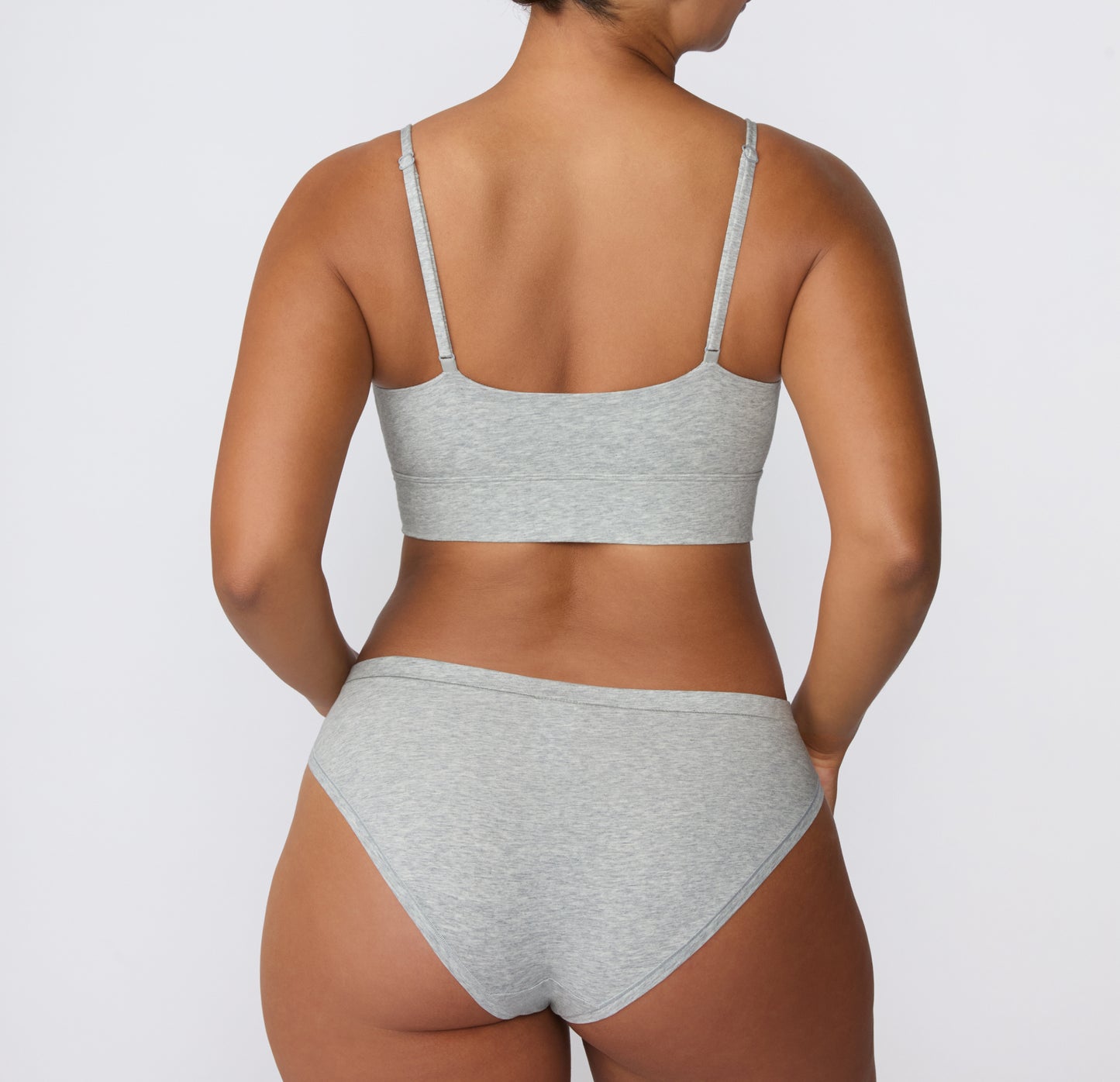 Back view on a light studio backdrop of the Cloud Cotton Bikini in Light Heather Grey, paired with the Cloud Cotton Thin Strap Bralette, showing the smooth back waistband and full back coverage.