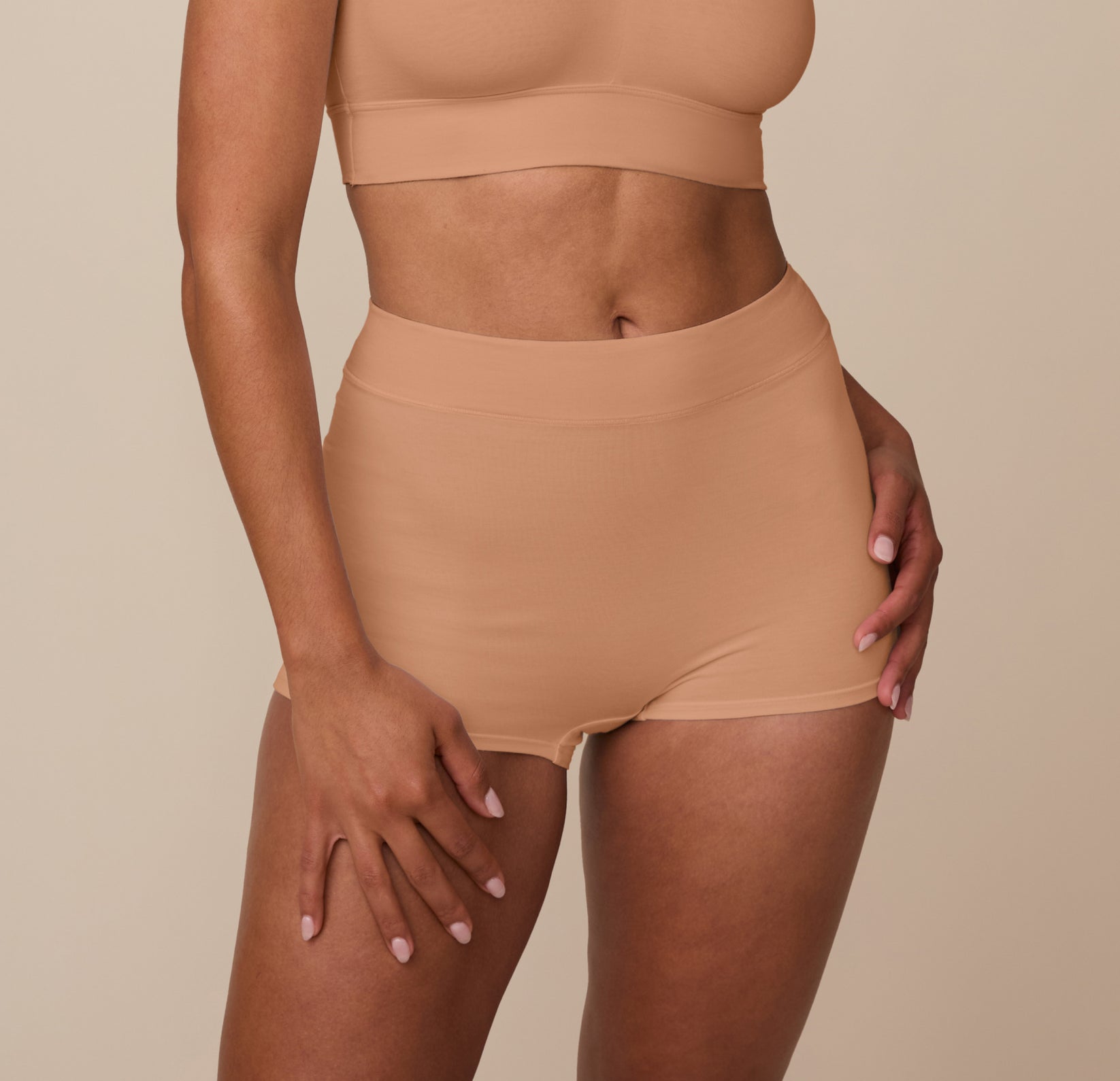 Close-up front view of Nemesis wearing the Cloud Cotton High Waist Boyshort in Dune. The image highlights the high-rise waistband and full coverage design made from a soft, breathable cotton-modal blend. sizing: Nemesis wears size Medium