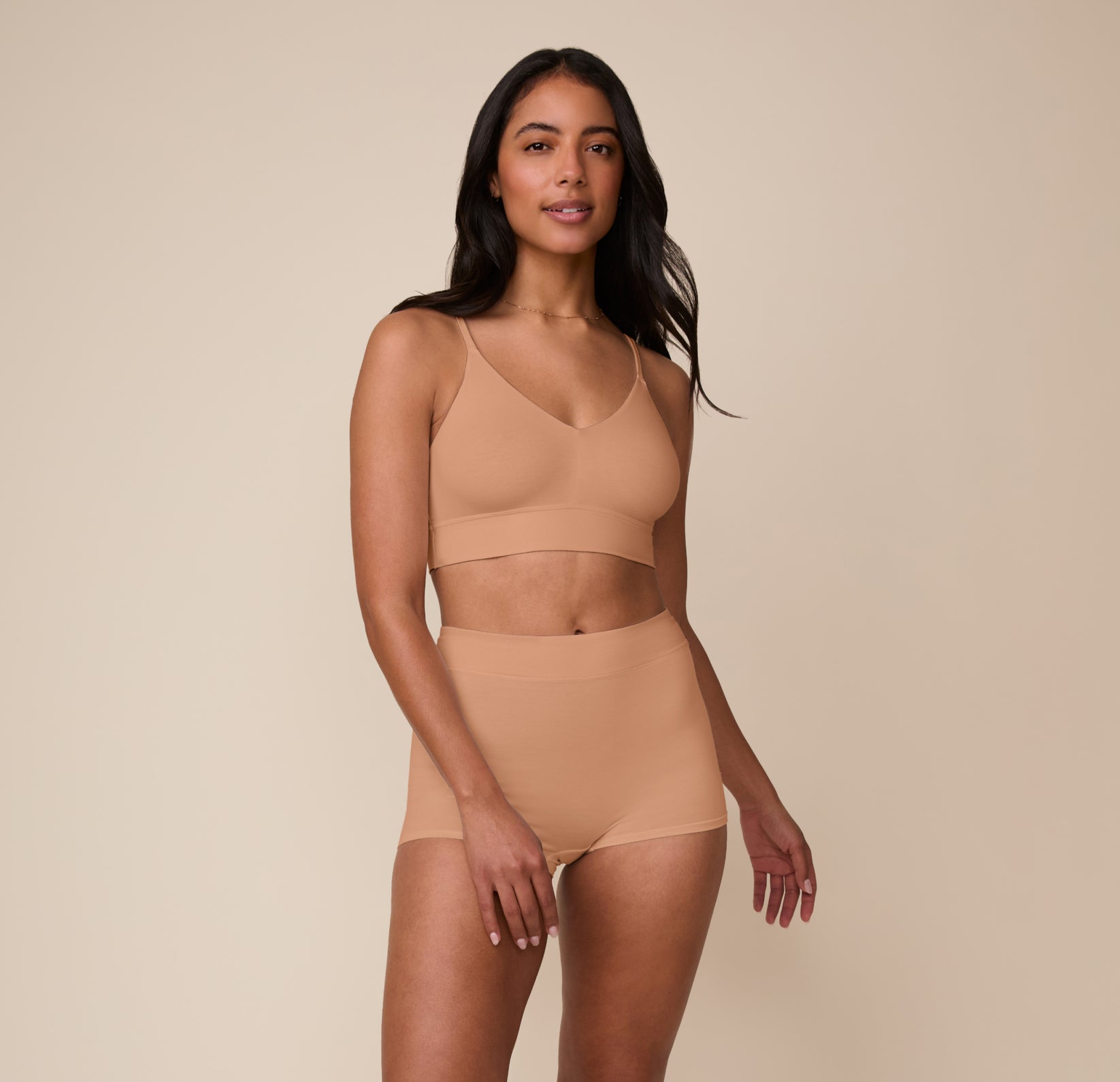 Full-body shot of Nemesis in the Cloud Cotton High Waist Boyshort and matching bralette in Dune. The set showcases a seamless, relaxed fit perfect for lounging or layering.
