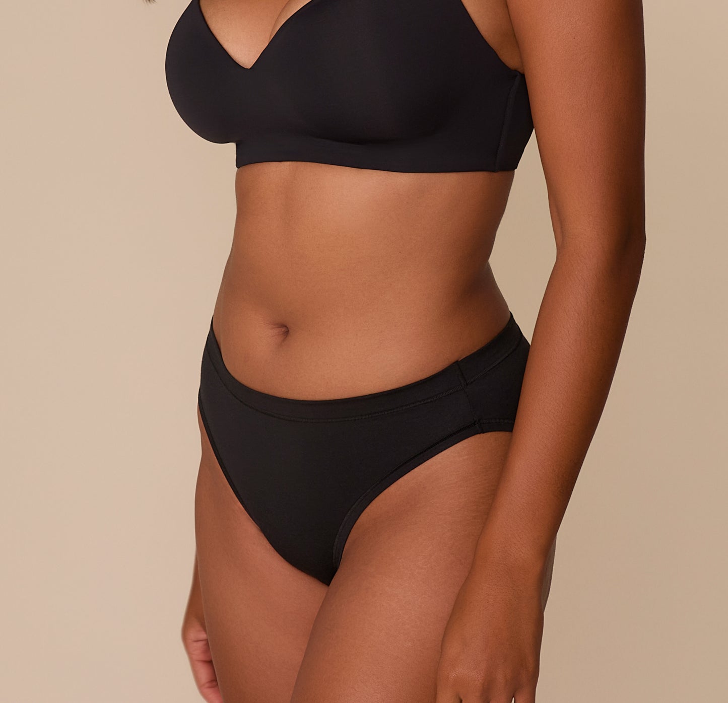 Side profile of Victoria modeling the Cloud Cotton French Cut Brief in Black, emphasizing the seamless fit along the hips and the flattering rise designed for everyday comfort.