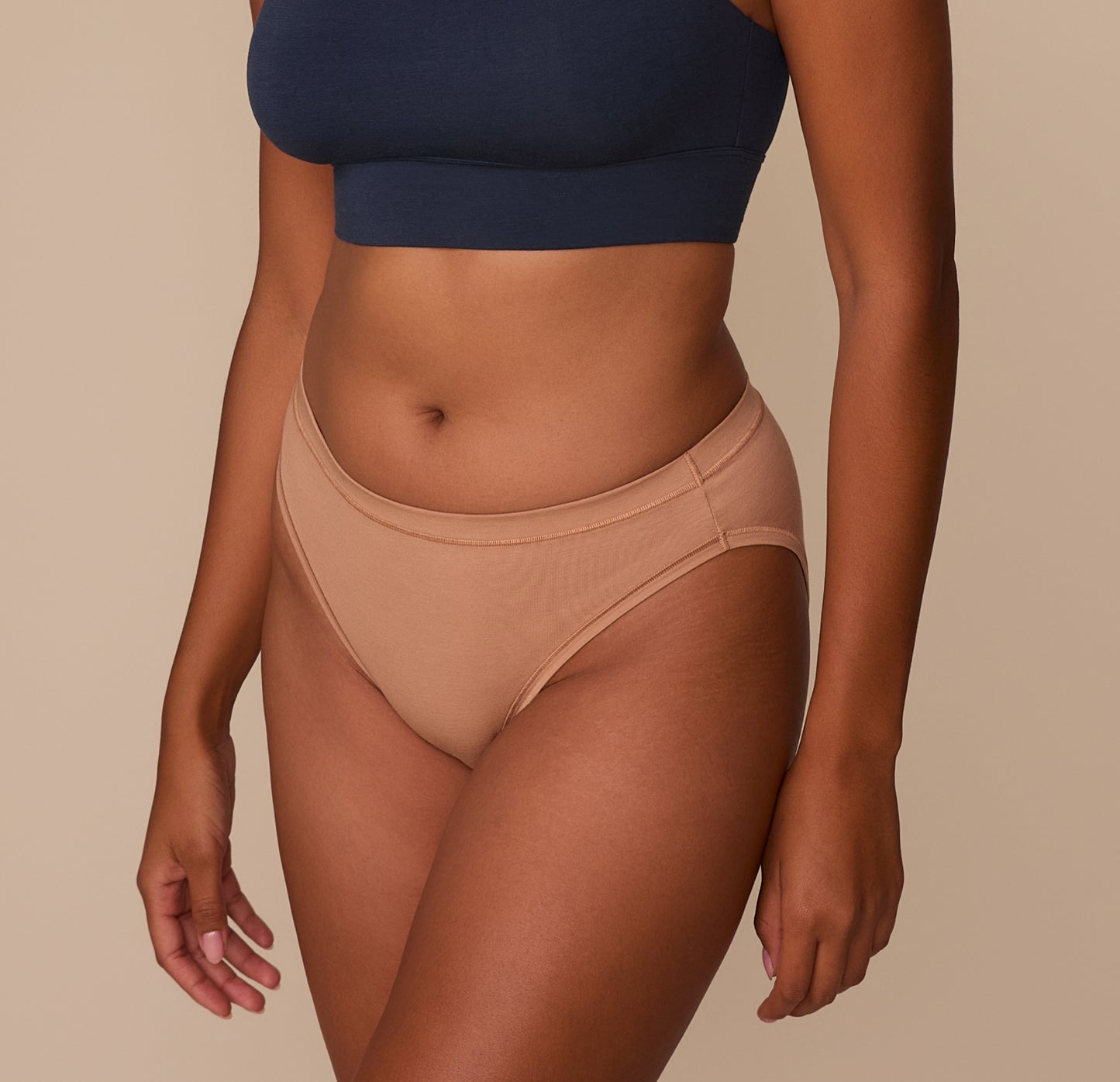 Side view of Victoria modeling the Cloud Cotton French Cut Brief in Dune. The brief's minimal side seams and breathable cotton-modal blend are showcased.