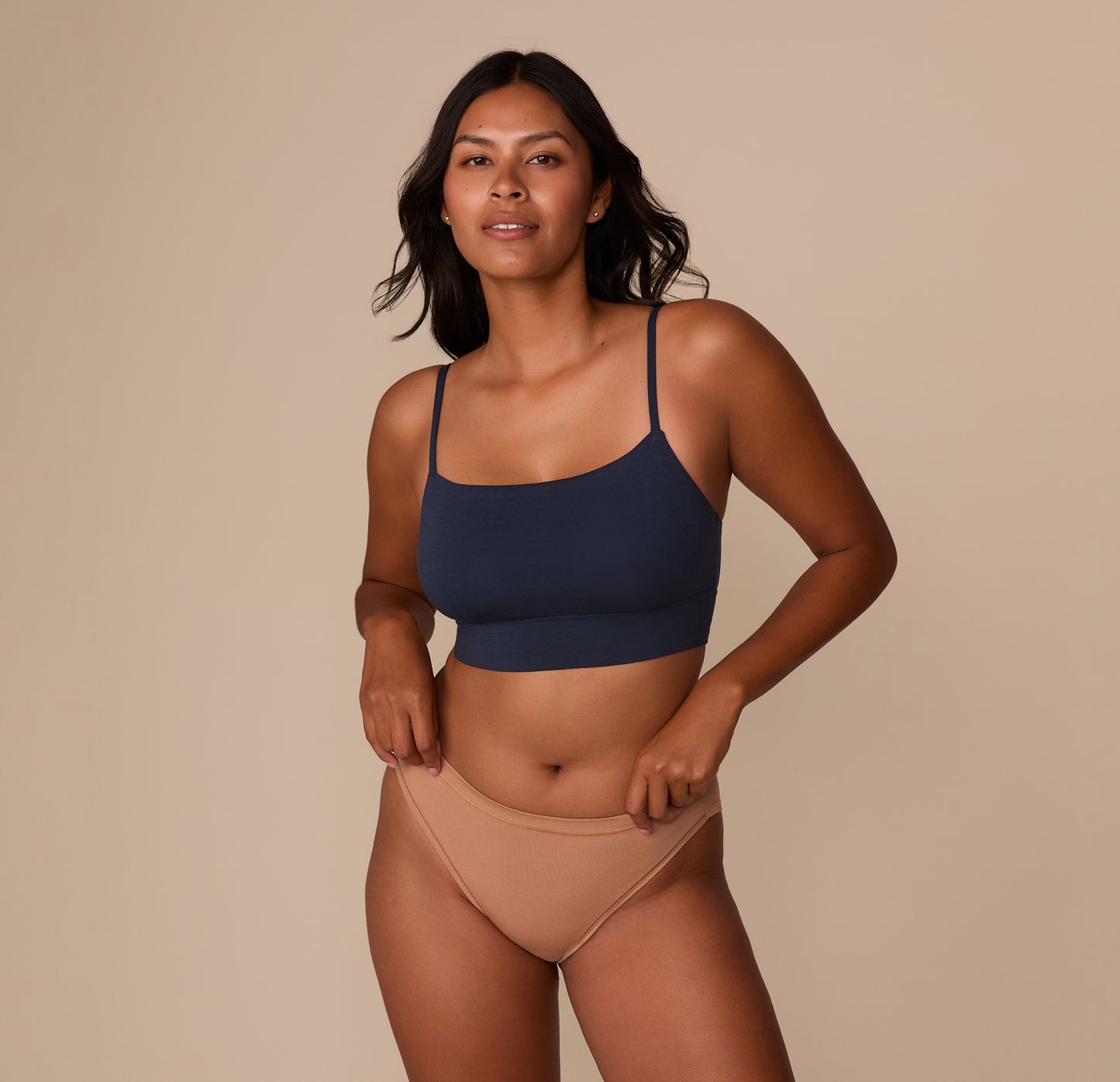 Victoria standing front-facing in the Cloud Cotton French Cut Brief in Dune, paired with the Cloud Cotton Thin Strap Bralette in Midnight. The image emphasizes the coordinated look and casual comfort of the set.