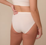 Back view of model Sonnie in the Cloud Cotton French Cut Brief in Quartz. The image showcases full back coverage with a smooth, clean finish.