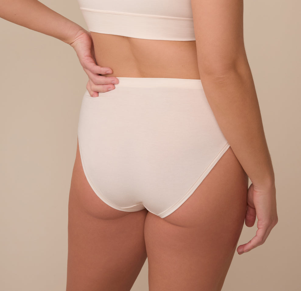 Back view of model Sonnie in the Cloud Cotton French Cut Brief in Quartz. The image showcases full back coverage with a smooth, clean finish.