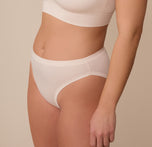 Side angle of model Sonnie wearing the Cloud Cotton French Cut Brief in Quartz. The image emphasizes the flattering high-leg silhouette and minimal seam side construction.