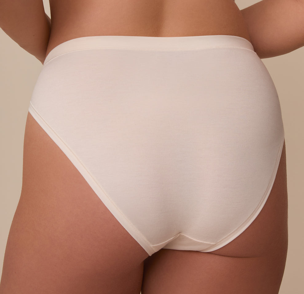 Close-up back view of model Sonnie in the Cloud Cotton French Cut Brief in Quartz. The image highlights the generous back coverage and the no-pinch fit of the waistband.
