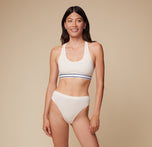 Anna stands facing the camera, wearing the Cloud Cotton Highwaist Thong in Heather Oatmeal with a matching Cloud Cotton Logo Racerback Bralette. The high waistband of the thong is emphasized. sizing: Anna wears size Small