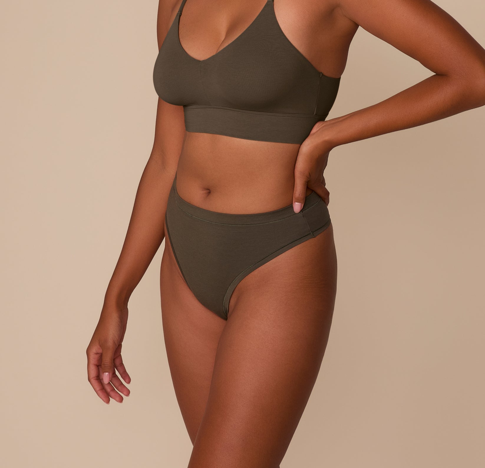 Side view of Victoria in the Cloud Cotton Highwaist Thong in Olive paired with the Cloud Cotton Triangle Bralette, showing the high-rise fit.