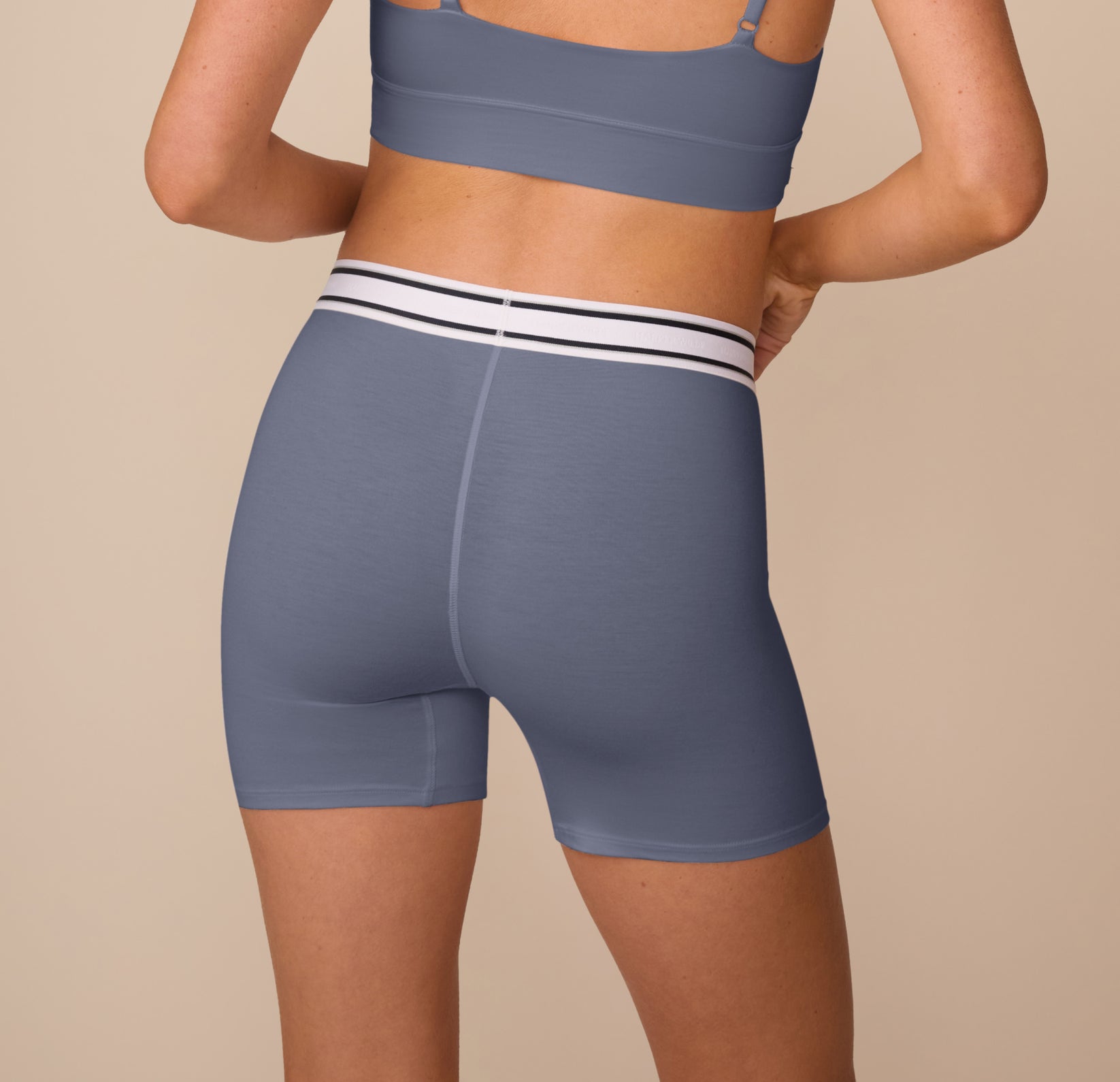 Back view of model Freya wearing the Cloud Cotton Boxer Brief in Slate. The image shows the smooth, full-coverage fit and wide waistband that provides gentle support.