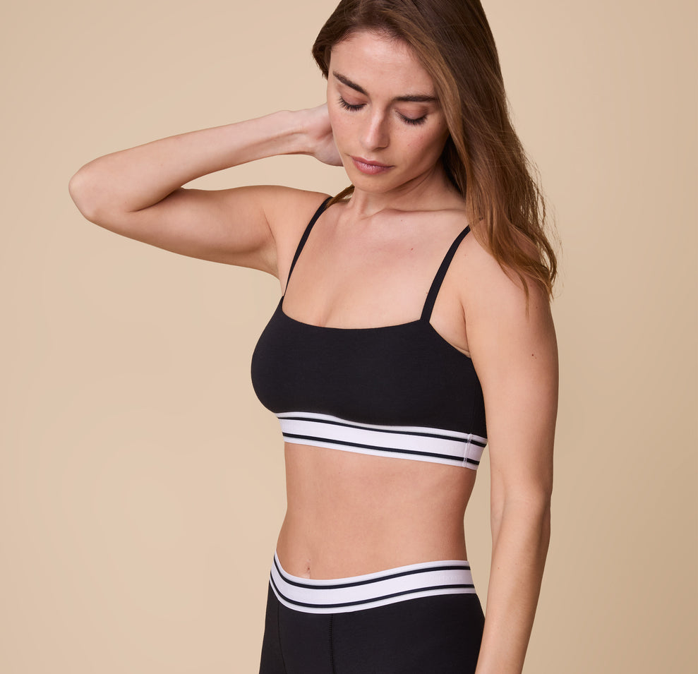 A three quarter profile of Gracie modeling the Cloud Cotton Retro Bandeau Bralette in Black, highlighting the smooth, stretchy fabric and the snug, flexible fit.