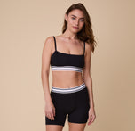 A full-length image of Gracie wearing the Cloud Cotton Retro Bandeau Bralette in Black, paired with the matching Cloud Cotton Boxer Brief in Black.