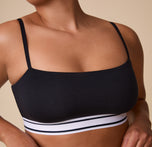 A close-up of India wearing the Cloud Cotton Retro Bandeau Bralette in Black, emphasizing the soft cotton material and the snug, supportive underband.