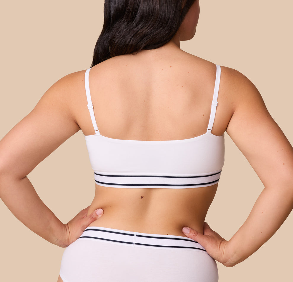 The back view of Emersyn wearing the Cloud Cotton Retro Bandeau Bralette in White, highlighting the smooth back with thin adjustable straps.