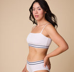 A three quarter profile of Emersyn in the Cloud Cotton Retro Bandeau Bralette in White, showcasing the soft, breathable cotton fabric and flexible fit.
