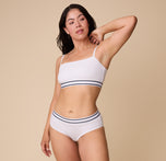 A full-length image of Emersyn in the Cloud Cotton Retro Bandeau Bralette in White, paired with the matching Cloud Cotton Hiphugger in White.