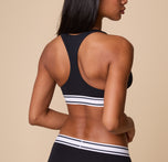 The back view of Ally wearing the Cloud Cotton Retro Racerback Bralette in Black, highlighting the racerback design for extra support and freedom of movement.