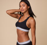 A relaxed side profile of Ally in the Cloud Cotton Retro Racerback Bralette in Black, showcasing the smooth cotton fabric and contoured fit.