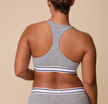 The back view of India wearing the Cloud Cotton Retro Racerback Bralette in Heather Charcoal, highlighting the racerback design for extra support and freedom of movement.