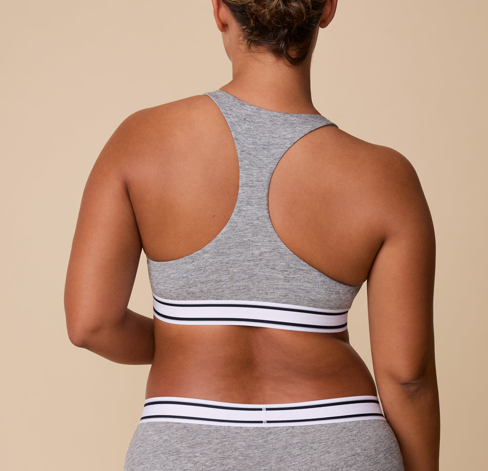 The back view of India wearing the Cloud Cotton Retro Racerback Bralette in Heather Charcoal, highlighting the racerback design for extra support and freedom of movement.
