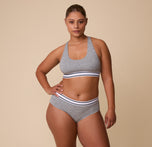 A full-length shot of India in the Cloud Cotton Retro Racerback Bralette in Heather Charcoal, paired with the matching Cloud Cotton Hiphugger in Heather Charcoal.
