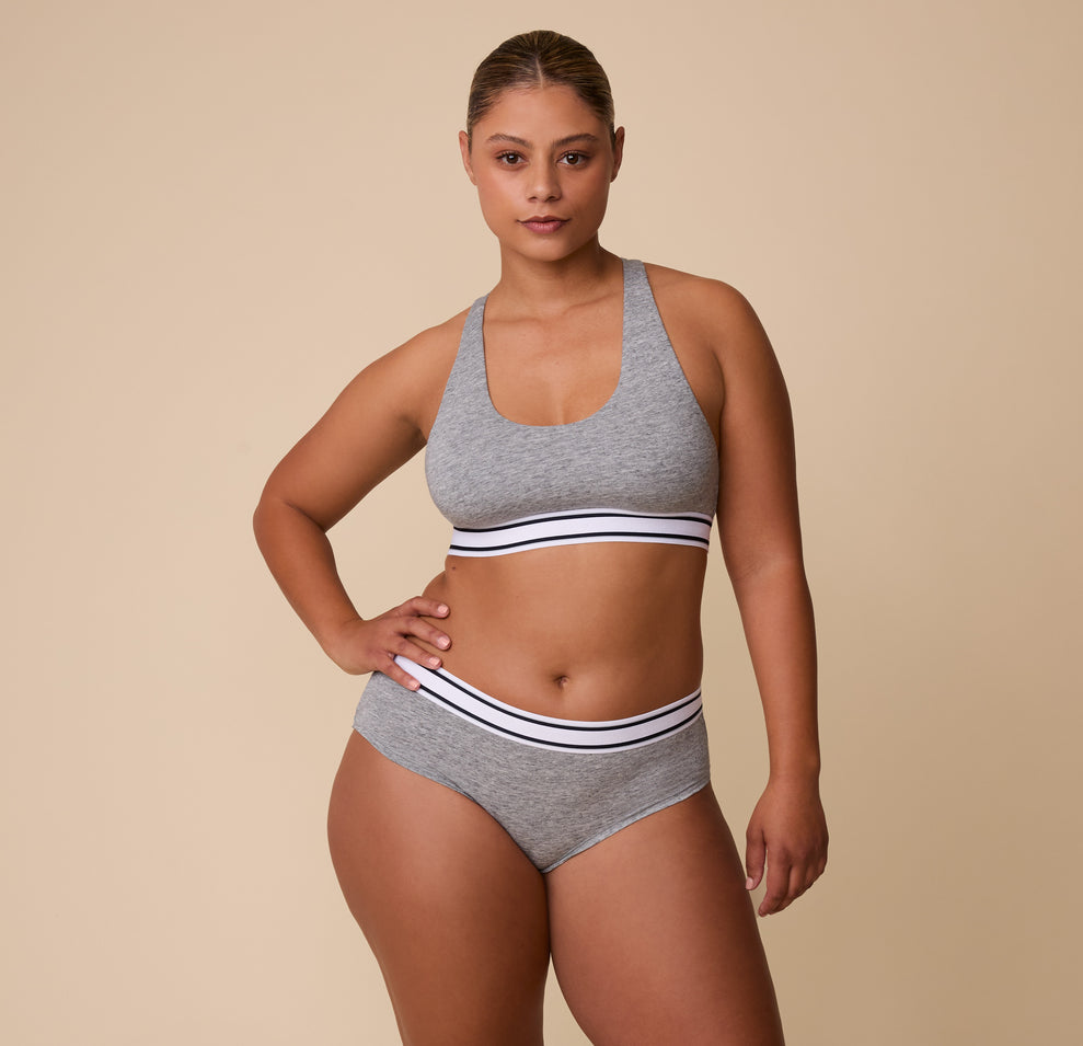 A full-length shot of India in the Cloud Cotton Retro Racerback Bralette in Heather Charcoal, paired with the matching Cloud Cotton Hiphugger in Heather Charcoal.