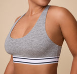 A detailed shot focusing on the soft, ribbed elastic underband of the Cloud Cotton Retro Racerback Bralette in Heather Charcoal. The comfortable, Cotton fabric and scoop neckline are emphasized.