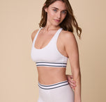 A three quarter view of Gracie wearing the Cloud Cotton Retro Racerback Bralette in White, showing the smooth fit and soft, breathable fabric.