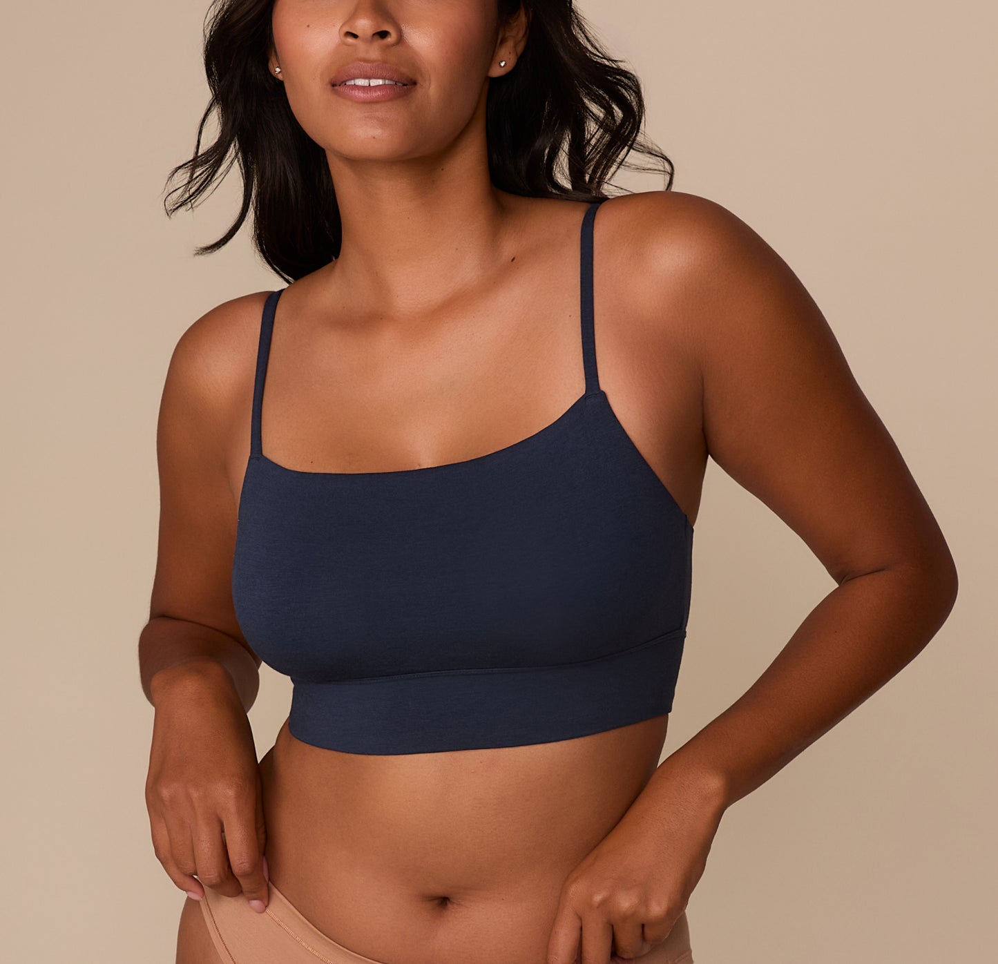 Victoria wearing the Cloud Cotton Thin Strap Bralette in Midnight, shown from the front. The bralette features a scoop neckline, thin adjustable straps, and a longline body in a soft cotton-modal blend. sizing: Victoria wears size Medium