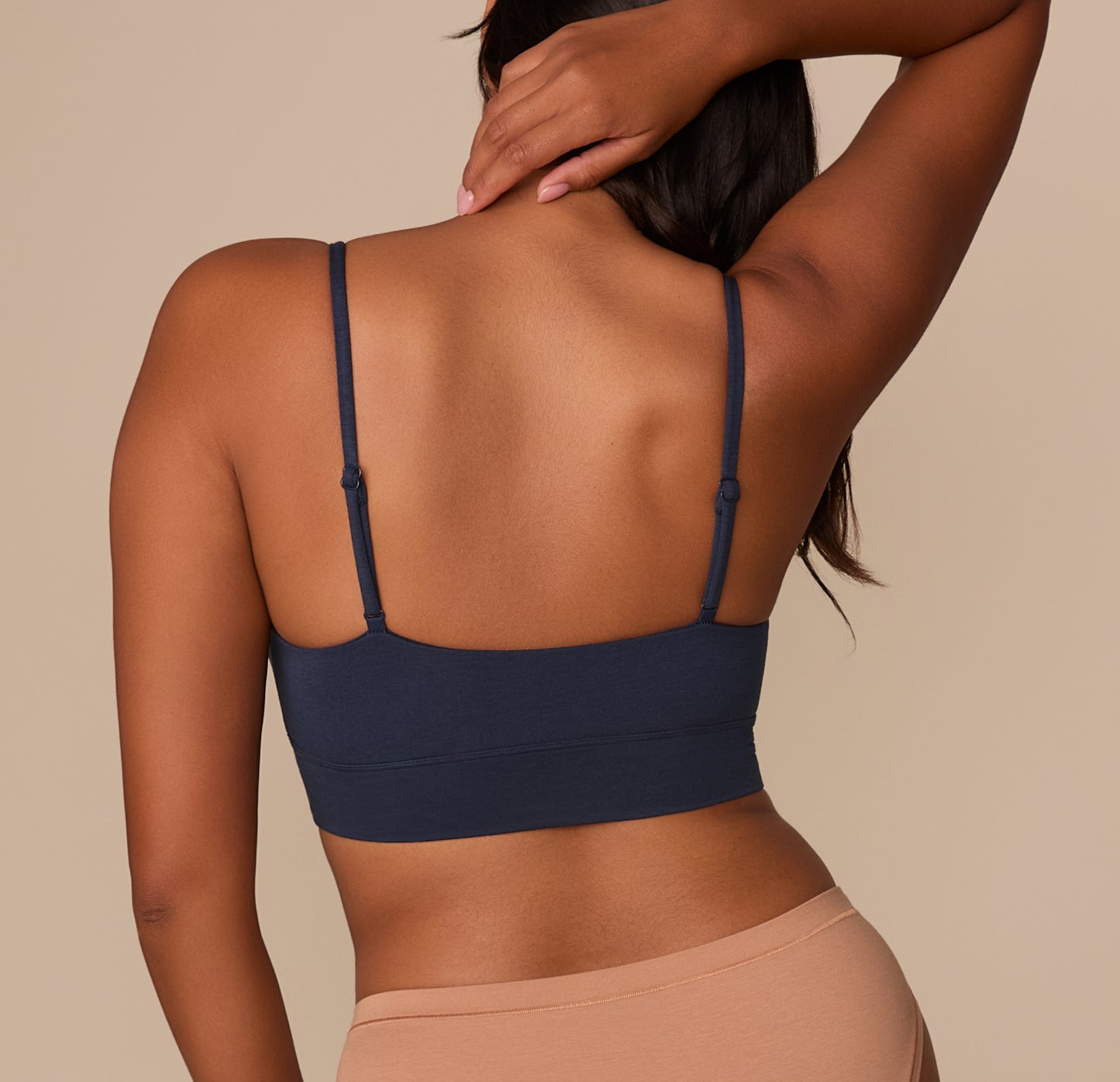 Back view of Victoria wearing the Cloud Cotton Thin Strap Bralette in Midnight, highlighting the smooth, scoop-back design and thin adjustable straps.
