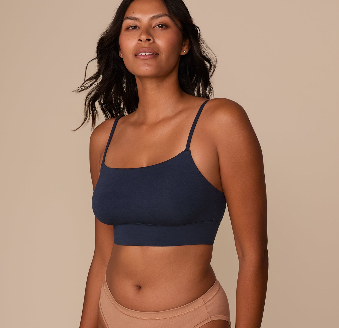 Victoria standing in a neutral pose wearing the Cloud Cotton Thin Strap Bralette in Midnight. The image showcases the bralette’s front coverage and comfortable, wire-free fit.