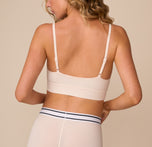 Back view of model Freya in the Cloud Cotton Thin Strap Bralette in Quartz. This shot shows the low-back design and adjustable straps for a flexible, supportive fit.
