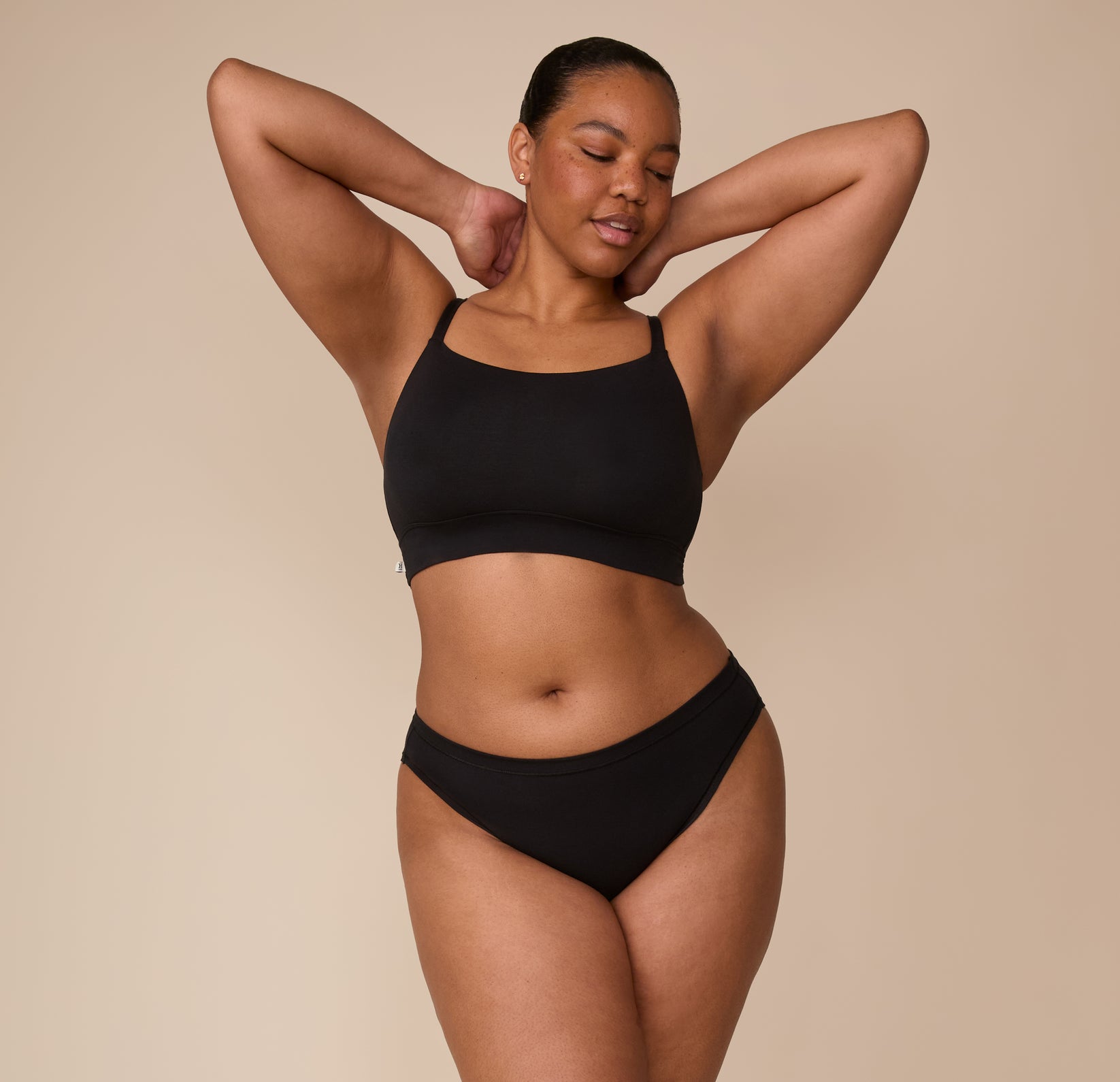 Zarria poses in the Cloud Cotton Thin Strap Bralette and matching Cloud Cotton Bikini in Black, showing the full set and how it contours to the body with comfort.