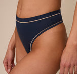 Side close-up view of Marcela wearing the Cloud Cotton Highwaist Thong in Midnight. This shot draws attention to the minimal seam side construction and soft-stretch fabric along the hip.