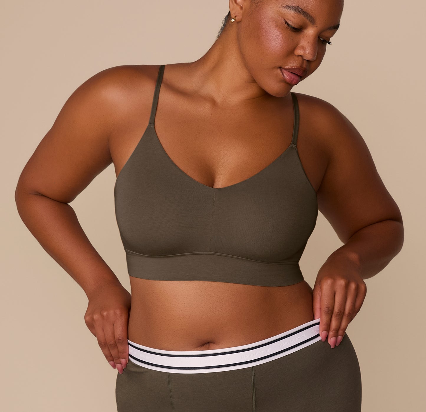 Zarria wearing the Cloud Cotton Triangle Bralette in Olive, shown from the front with matching Cloud Cotton Retro Boxer Brief. The bralette has a deep V neckline, longline body, and thin adjustable straps. sizing: Zarria wears size XL