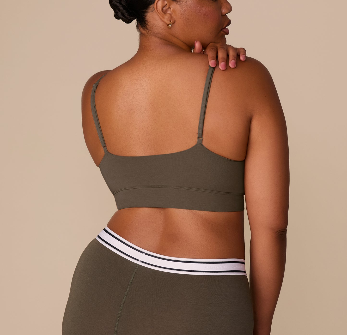 Back view of Zarria wearing the Cloud Cotton Triangle Bralette in Olive, highlighting the smooth band and adjustable straps.