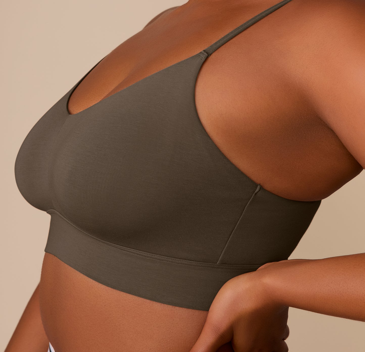 Side view close-up of Zarria wearing the Cloud Cotton Triangle Bralette in Olive, focusing on the longline body and smooth cotton-modal fabric.
