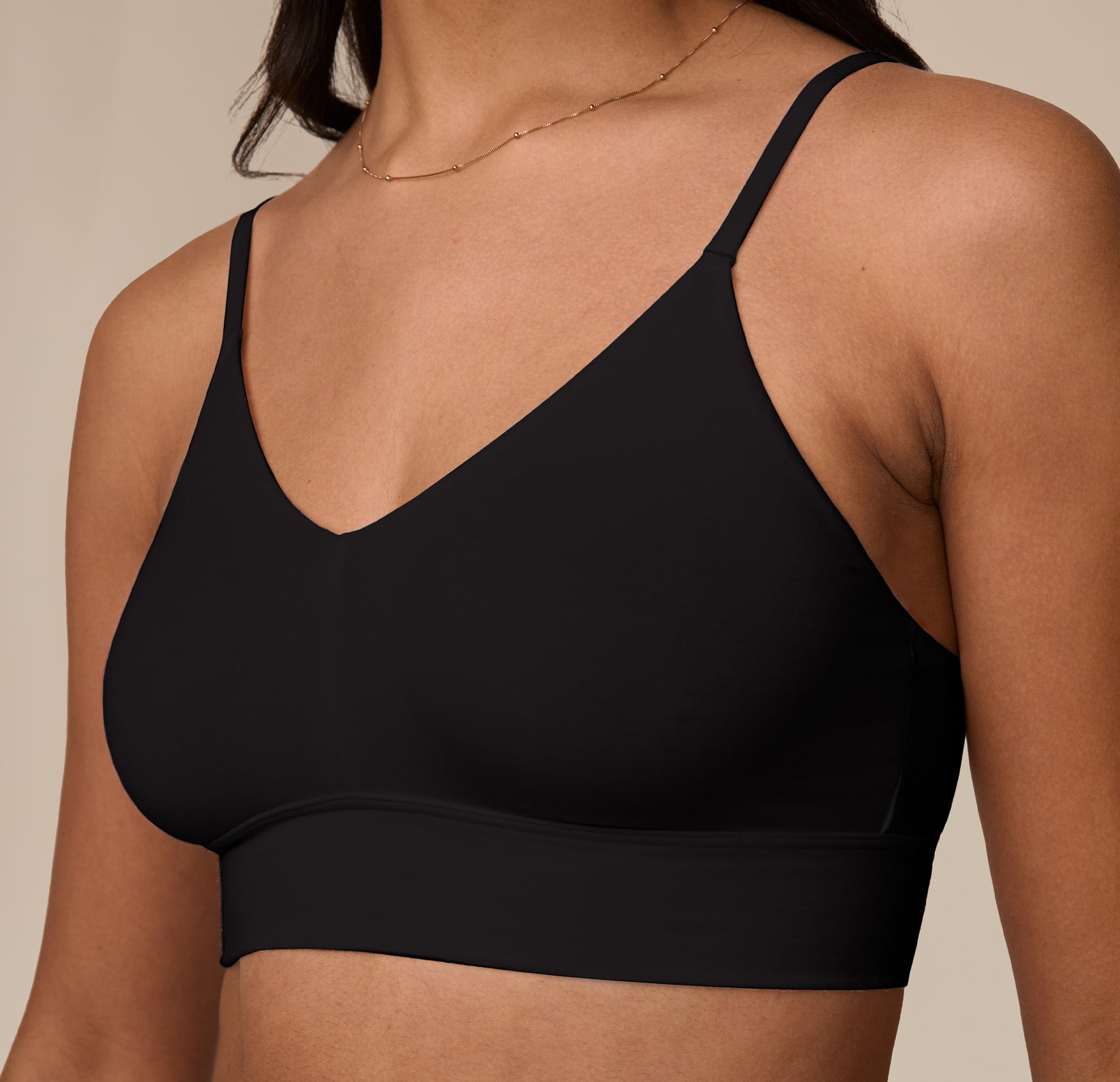 Close-up detail of Nemesis wearing the Cloud Cotton Triangle Bralette in Black. The bralette’s clean finish stitching are visible along the neckline and underband.