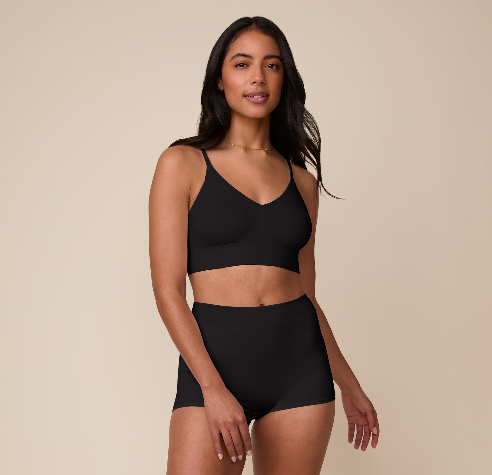 Full-body shot of Nemesis in the Cloud Cotton Triangle Bralette and matching Cloud Cotton Highwaist Boyshort in Black. The look emphasizes the minimal, second-skin fit designed for everyday wear.