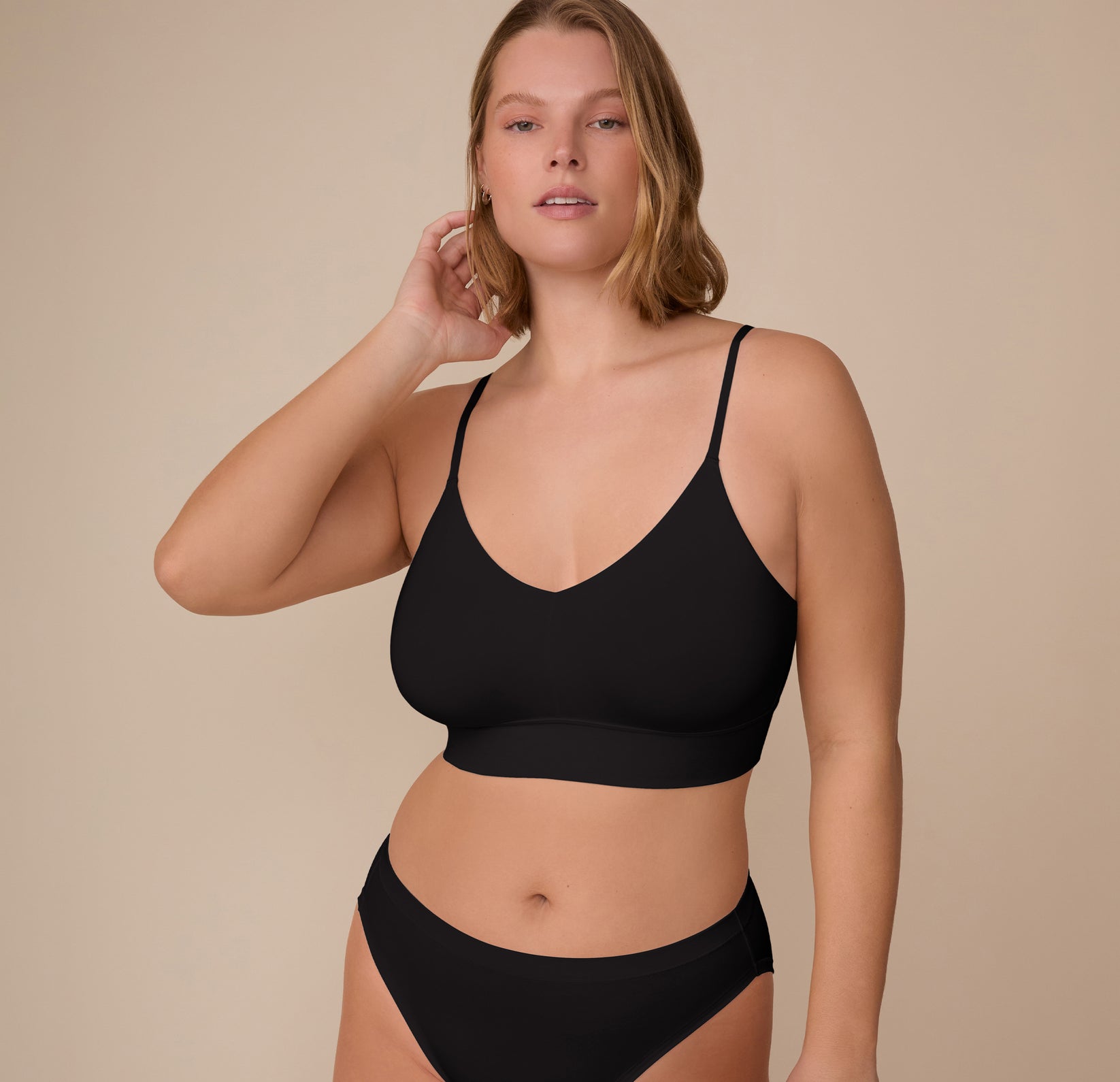 Sonnie wearing the Cloud Cotton Triangle Bralette in Black, shown from the front. The soft V-neck and wide elastic band provide gentle lift and a barely-there feel. sizing: Sonnie wears size XL